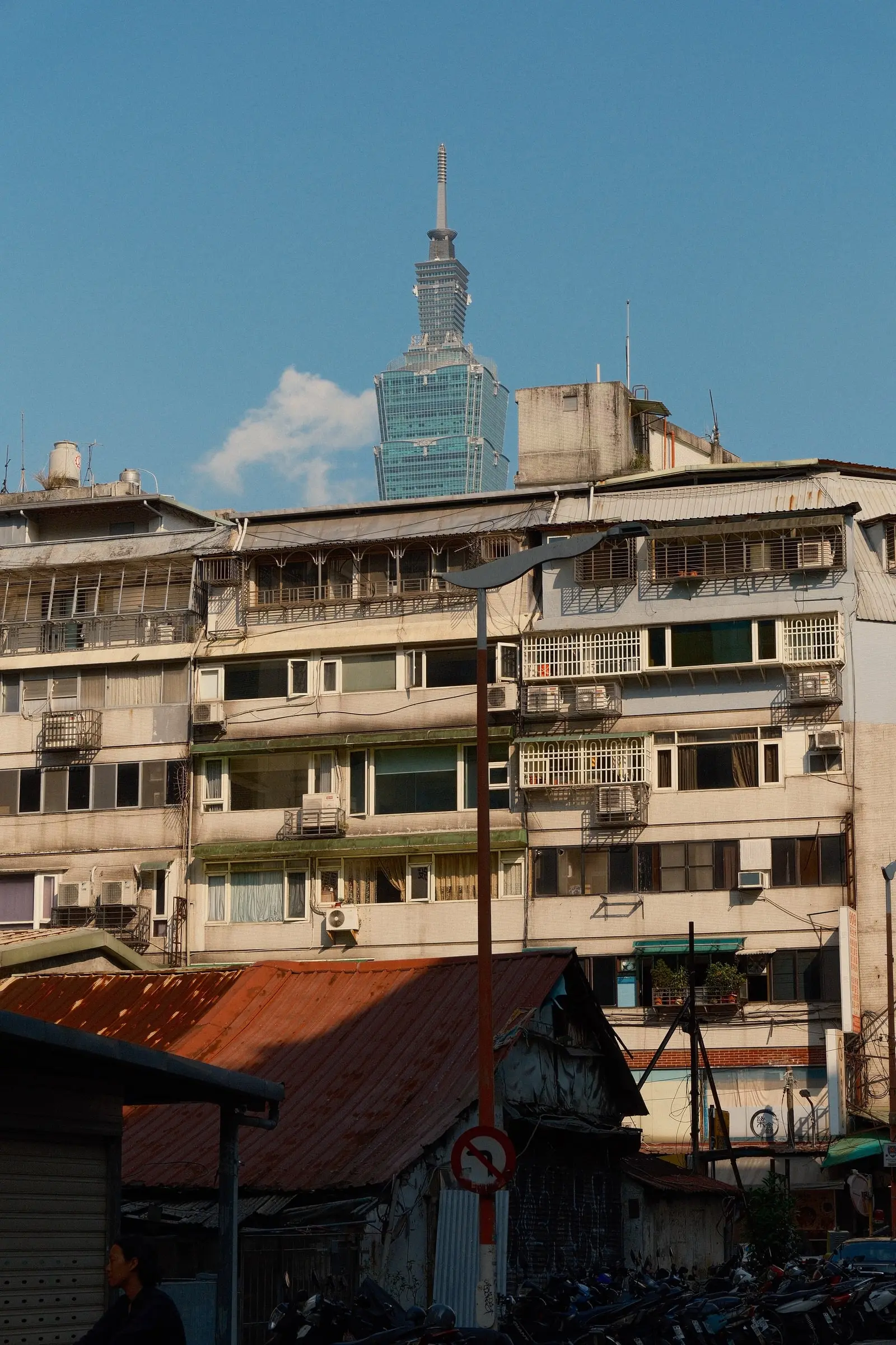 Taipei 101 rising behind an old apartment block — Taipei